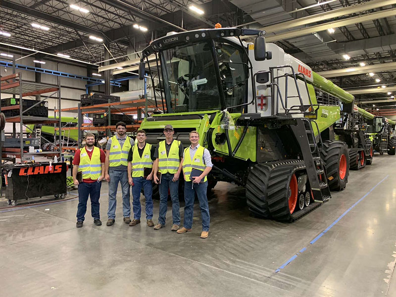 Team standing in front of a CLAAS machine inside the CLAAS factory.