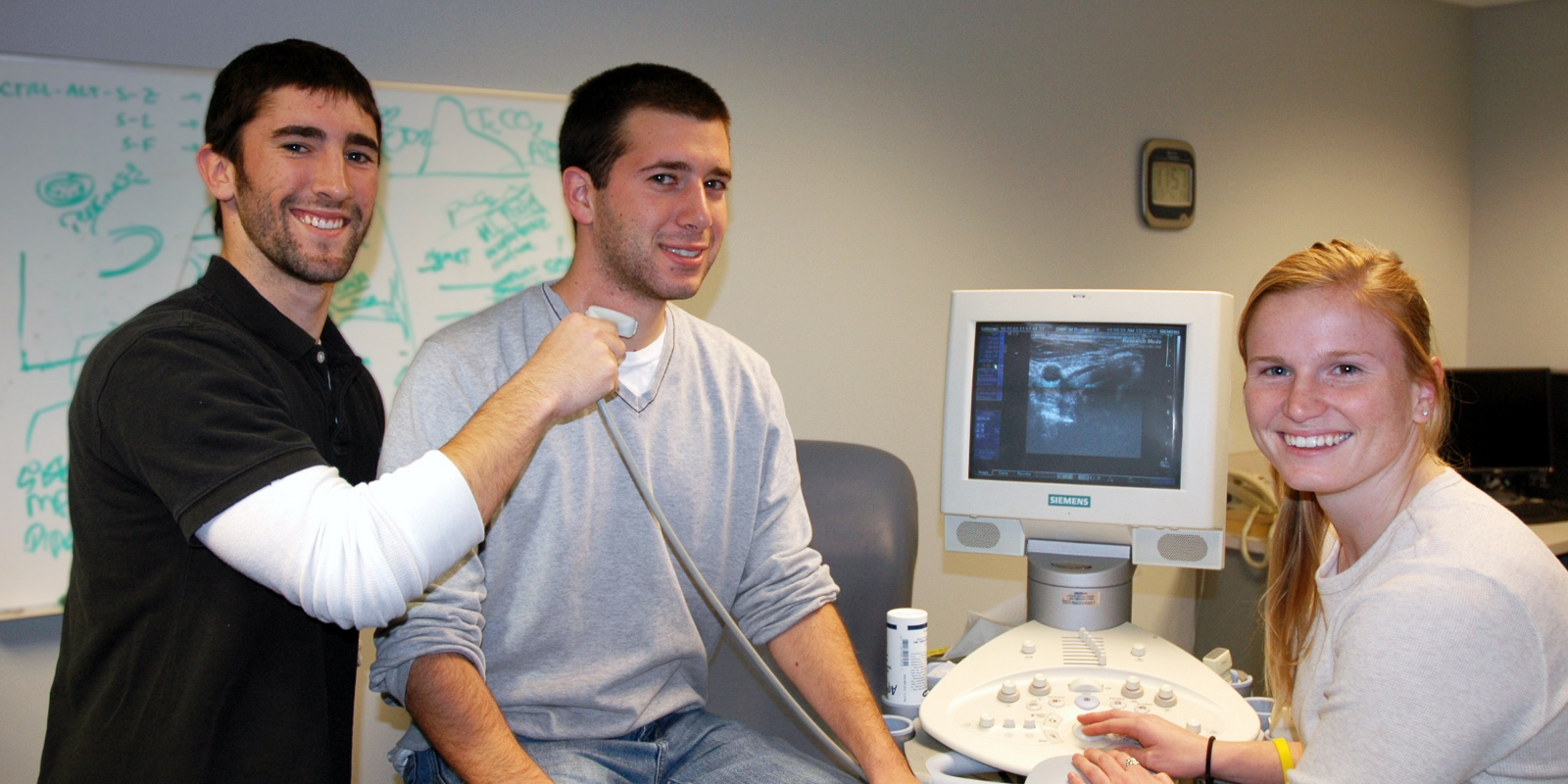 Three students working with the ultrasound machine in Dr. Bashford's lab