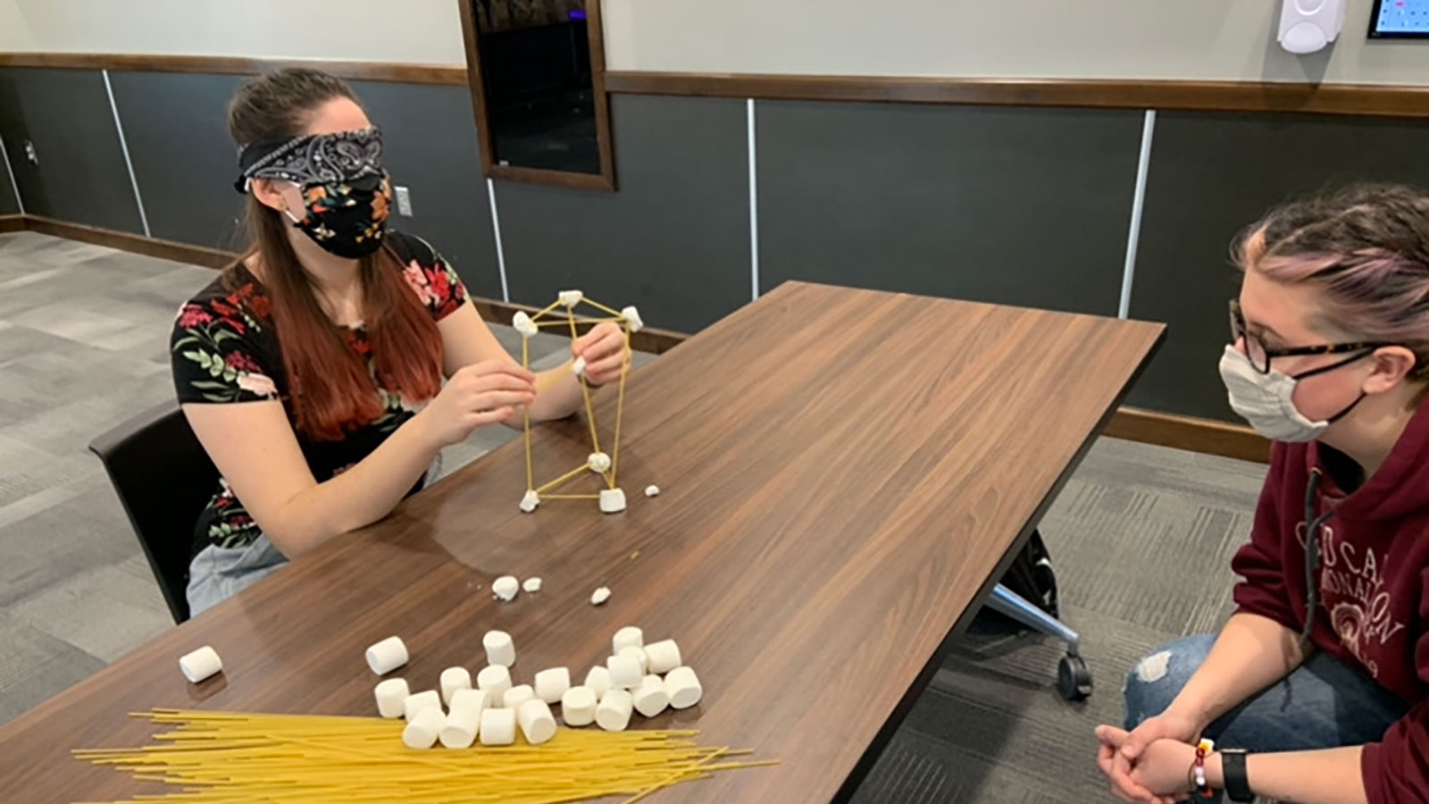 A team of 2 oSTEM members work together blindfolded to create a spaghetti tower building at a COVID-friendly event in 2020.