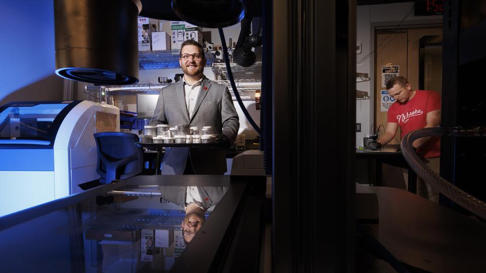 Male professor standing by a 3D printer