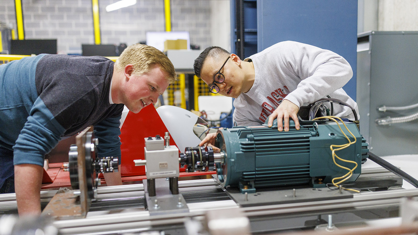 Two male students looking at an engine