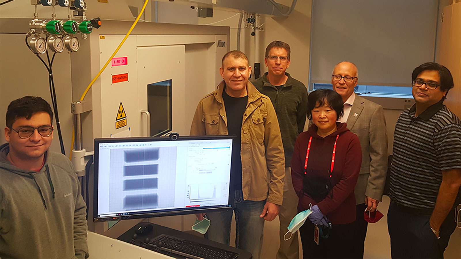 Researchers from the Nano-engineering Research Core Facility (NERCF) – (from left) Andrew Menendez, Ziyad Smoqi, Jeff Shield, Wen Qian, Joseph Turner, Prahalada Rao – stand with the new Nikon X-Ray Computed Tomography machine that can make high-powered, 3D scans of materials.