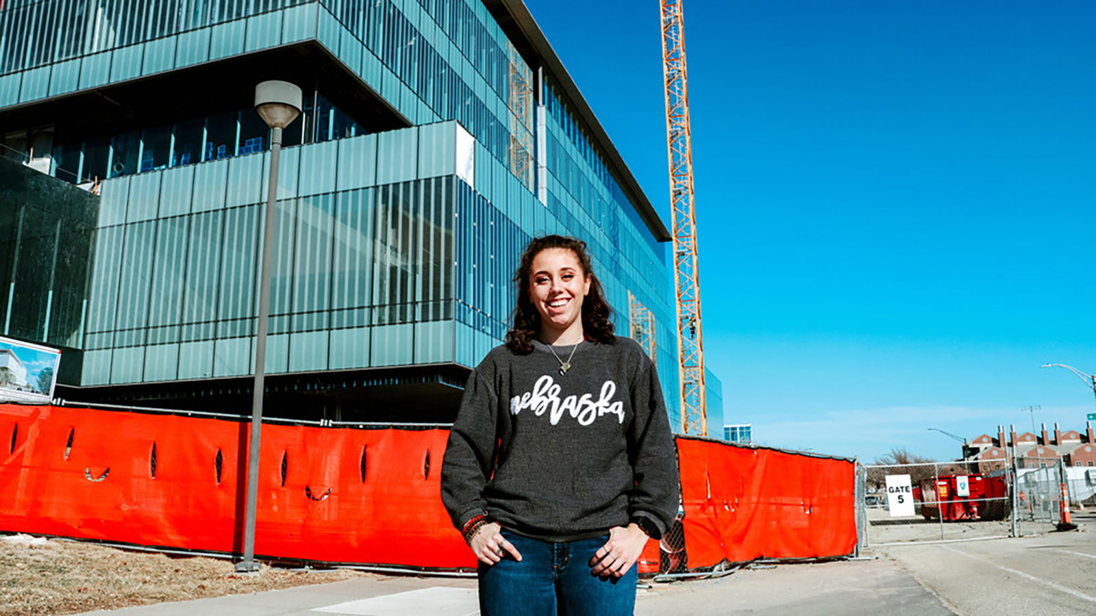 Taylor Hosik standing in front of Kiewit Hall, currently under construction on the University of Nebraska-Lincoln City Campus.