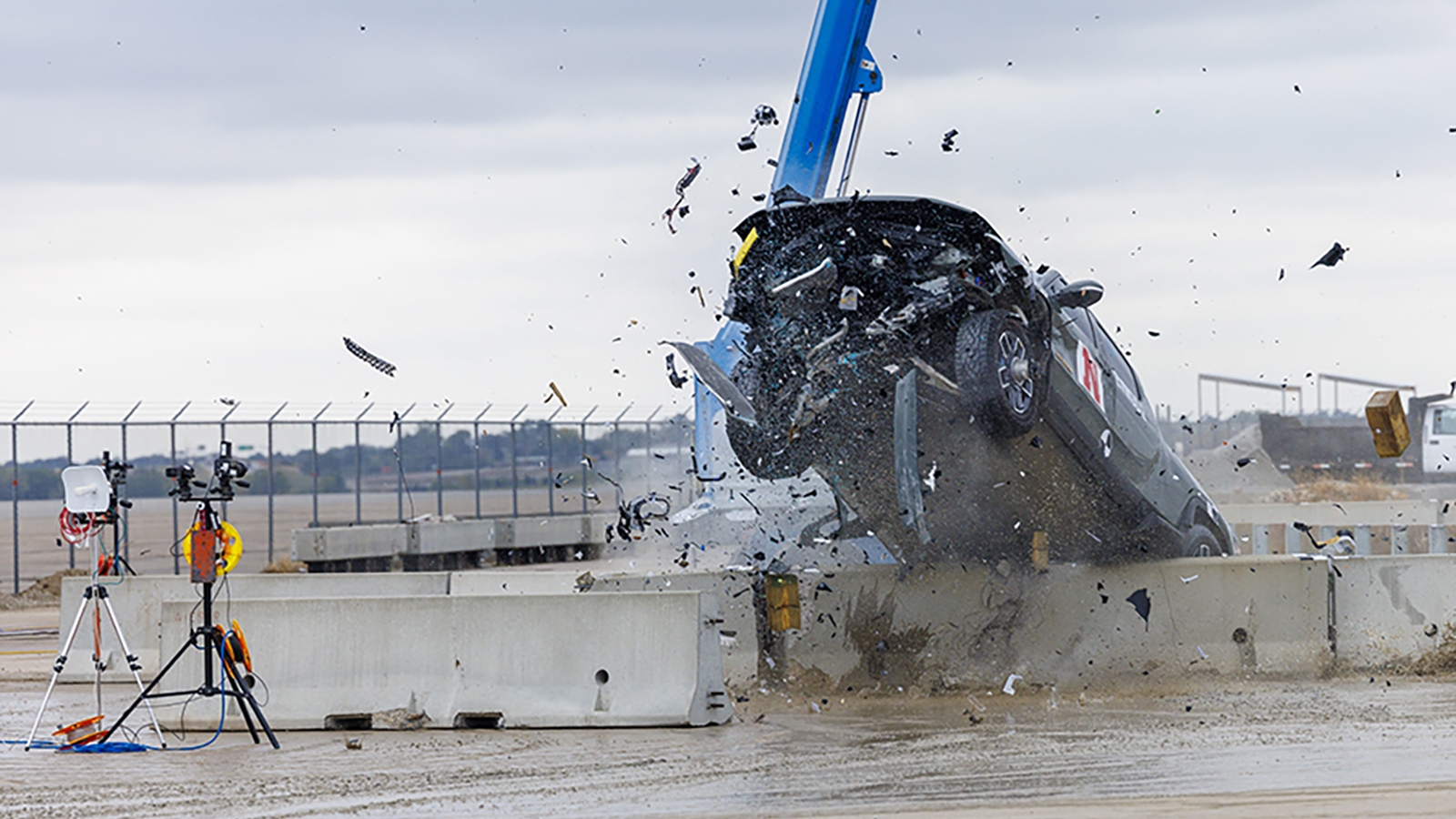 An electric vehicle is crash tested against a concrete barrier