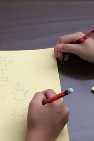 Kids drawing a robot on a piece of paper