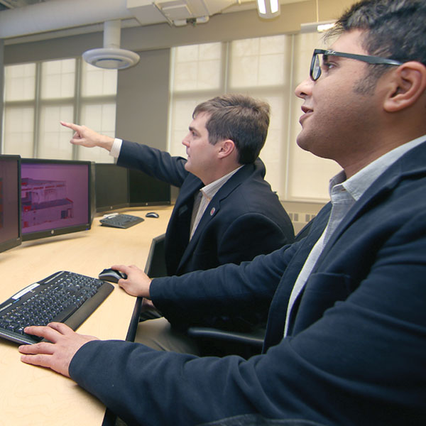 Richard Wood, assistant professor of civil engineering, and doctoral student Ebrahim Mohammadi check the structural integrity of a building using their new software program.University of Nebraska-Lincoln civil engineers have developed 3-D software that can visually identify damage in a range of structures, from bridges in Nebraska to temples in Nepal.
