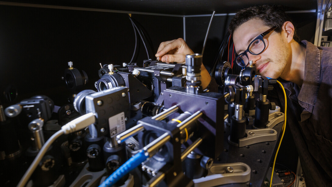 Adam Erickson from Abdelghani Laraoui’s lab in the Engineering Research Center aligns the nitrogen vacancy scanning probe microscope used for the study. (Craig Chandler / University Communication and Marketing)