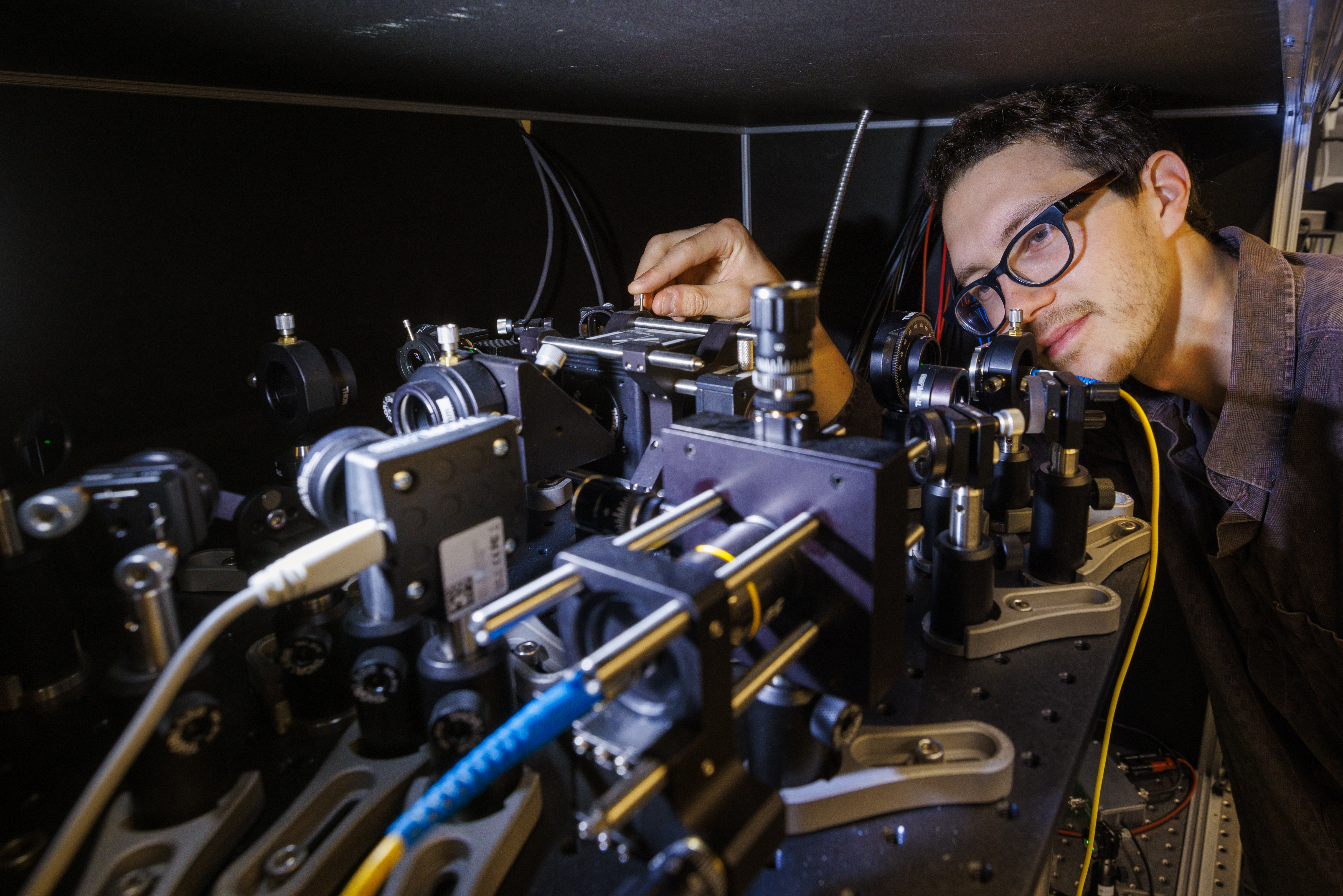 Doctoral student Adam Erickson adjusts the nitrogen-vacancy scanning probe in Abdelghani Laraoui's lab. (Craig Chandler / University Communication and Marketing)