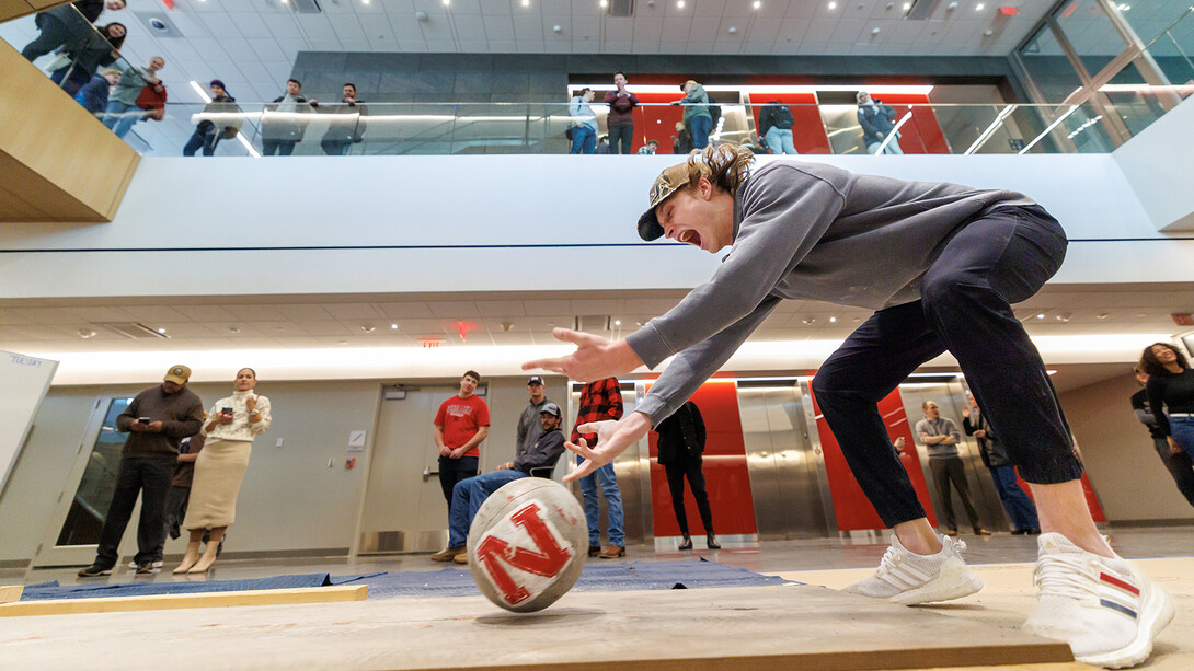 Quinn Gossett, a junior in construction management, rolls his ball down the lane with enthusiasm during the Concrete Bowling Competition in the Kiewit Hall Basement on Dec. 11. (Jordan Opp / University Communication and Marketing)