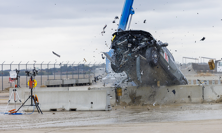 A 7,000-plus-pound, 2022 Rivian R1T truck tears through a concrete barrier during an October 2023 crash test at the Midwest Roadside Safety Facility's outdoor proving grounds at the Lincoln Airport. (Craig Chandler / University Communication and Marketing)
