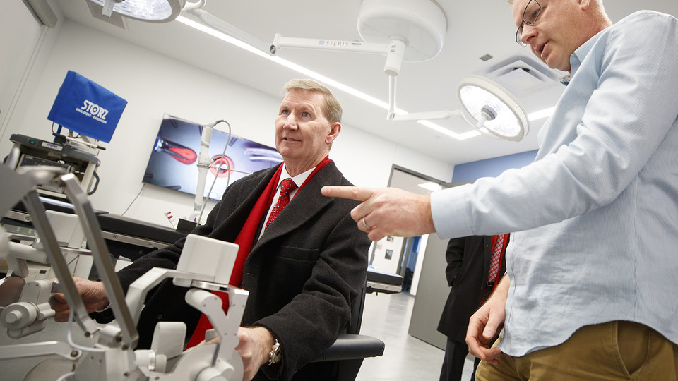 Shane Farritor (right), professor of mechanical and materials engineering, helps Ted Carter control a surgical robot in a Virtual Incision lab at Nebraska Innovation Campus. Carter’s two-day tour included stops at City, East and Nebraska Innovation campuses.