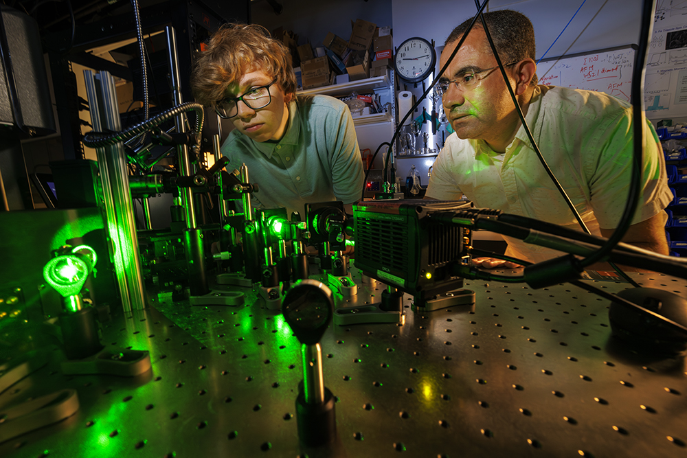 Abdelghani Laraoui (right), assistant professor of mechanical and materials engineering, and Ben Hammons, a first-year student in electrical and computer engineering, adjust a laser in Laraoui's Quantum Sensing & Defect Discovery and Spectroscopy Lab. (Craig Chandler / University Communication and Marketing)