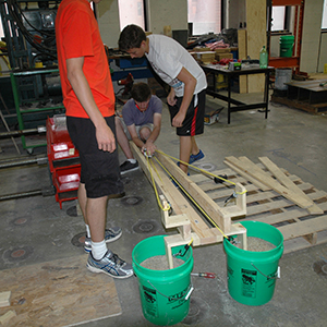 A team of campers tests its crossbow-inspired catapult design on Friday in the high bay area of Scott Engineering Center.