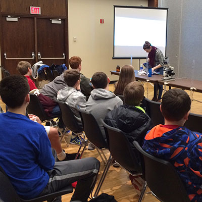 Rachel Levine, vice president of UNL's AWWA/WEF student chapter and a graduate student in civil engineering, shows middle school students an experiment during the Global Day of the Engineer, Feb. 24 at the Nebraska Union.