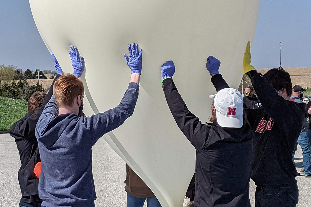 Members of the Big Red Satellite Team assist in the inflation of a high-altitude balloon in April 2021. The team of UNL and area students in grades 7-12 is scheduled to launch a payload of perovskite solar panels on Saturday, June 18 from Nebraska Innovation Campus.