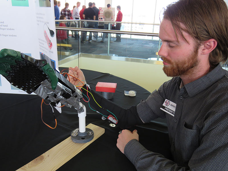 Student working with a device for the Senior Design Showcase 