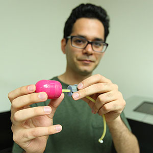 Hossein Dehghani, a doctoral candidate in mechanical and materials engineering, holds a prototype of his alternative to the traditional colonoscope that physicians use when searching for pre-cancerous or cancerous polyps in the large intestine.