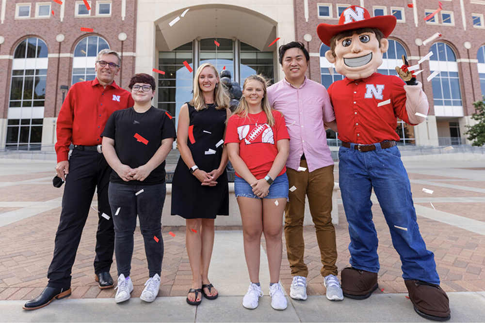Jenna Huttenmaier (third from left) won the vaccine registry giveaway grand prize, a trip for two with Chancellor Ronnie Green (left) to a 2022 Husker football game in Ireland. (University Communication)