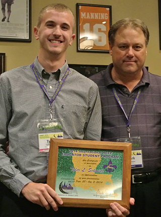 UNL Construction Management graduate student Tyler Schmidt receives a plaque after taking first place in student presentations at the IHEEP 2014 Convention in New Orleans.