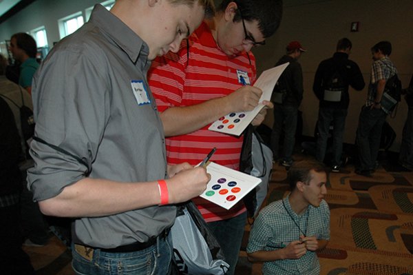 Students fill out their cards after collecting stickers during the scavenger hunt at the Company Expo at CenturyLink Center.