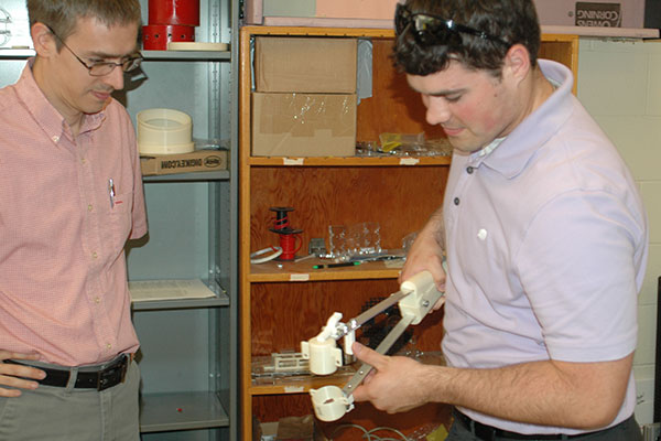 Faculty advisor Carl Nelson (left) and ASR project manager Luke Monhollon test a collection tool in a Scott Engineering Center laboratory.