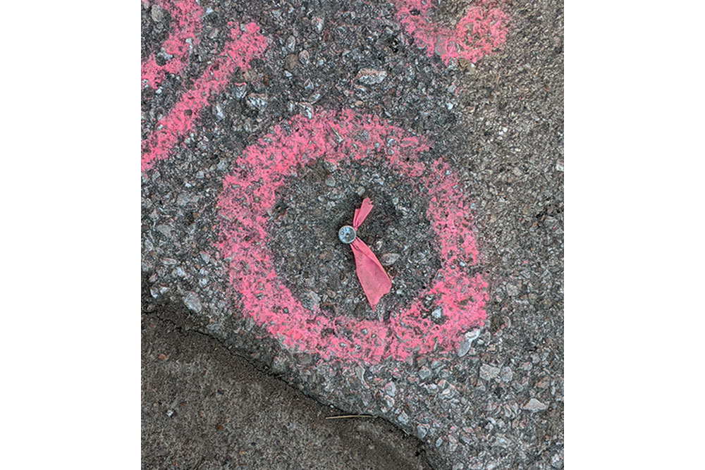 A nail with a pink ribbon inside a spray-painted circle in the asphalt northeast of Scott Engineering Center marks the spot where one of the corners of the new building will be.
