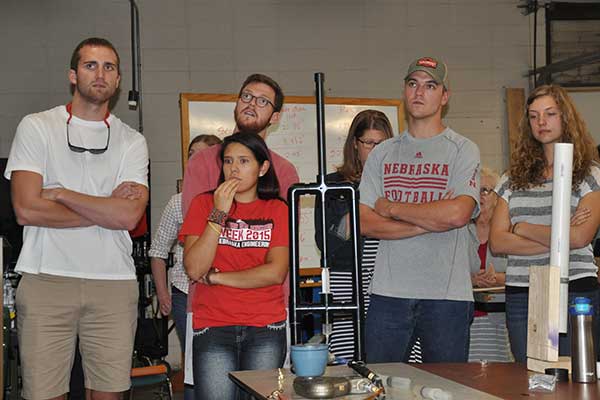 Christian Jewett, Mackenzie Miller, Kyle Olson, Kevan Reardon and Paula Sandoval watches as its device's performance is displayed on a screen at the Rapid Design Challenge.