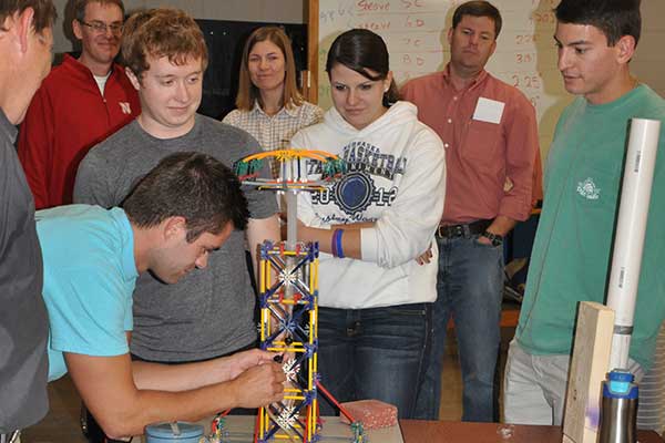 Zach Janecek attaches a tube to a syringe as teammates (from left) Michael Moeller, Kate Watts and Brinson Chapp watch at the Rapid Design Challenge.