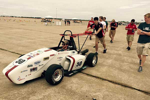 Husker Motorsports team members push the car to the track before a Thursday competition during the Formula SAE Lincoln event at Lincoln Airpark June 17-20.