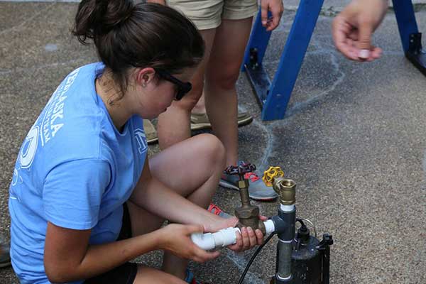 Bethany Brittenham works on the water pump as the UNL Fountain Wars team prepares its entry for the competition.