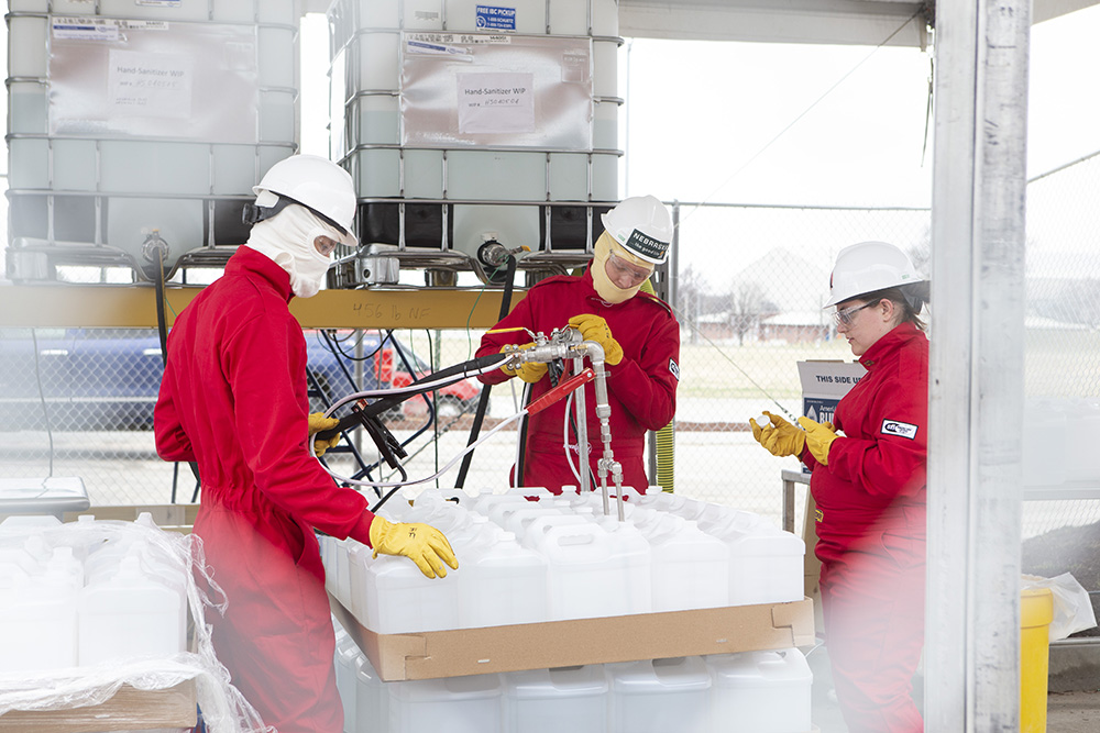 Hunter Flodman, Russell Parde and Sarah Herzinger work in the parking lot staging grounds during Monday's hand sanitizer production. (Nebraska Ethanol Board photo)