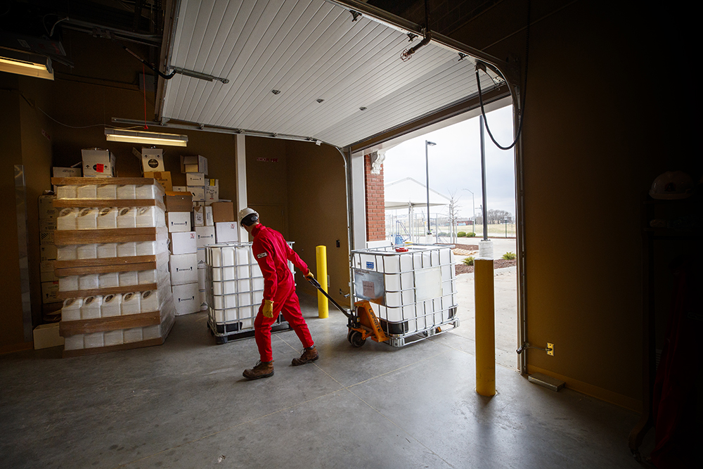 Hunter Flodman, assistant professor of practice in chemical and biomolecular engineering, moves a container of chemicals into the mixing room at Food Innovation Center. (Craig Chandler / University Communication)