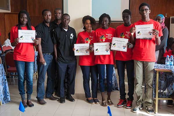 Sidy Ndao, assistant professor of mechanical and materials engineering, hands out certificates to the students after they completed the SenEcole robotics camp in Dakar, Senegal this past March.