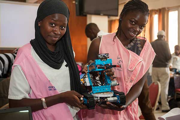 Two female students show off their assembled robot on the first day of the SenEcole robotics camp in Dakar, Senegal, this past March.