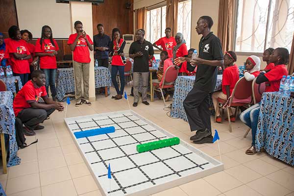Sidy Ndao (right), assistant professor of mechanical and materials engineering, presents the competition field to the students on the third day of the SenEcole robotics camp in Dakar, Senegal this past March.