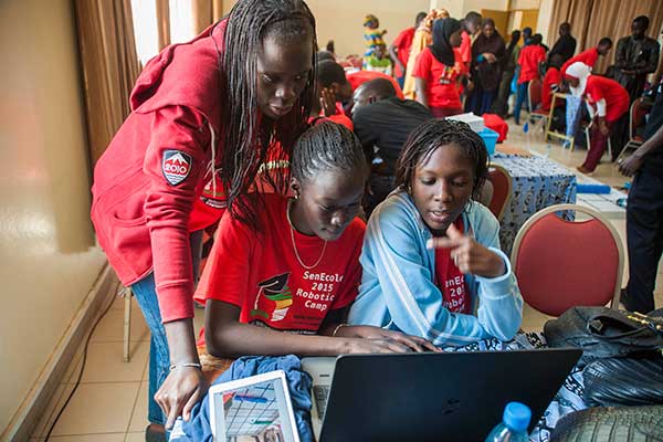 Three students work to finish programming their team's robot during the third day of the SenEcole robotics camp in Dakar, Senegal this past March.