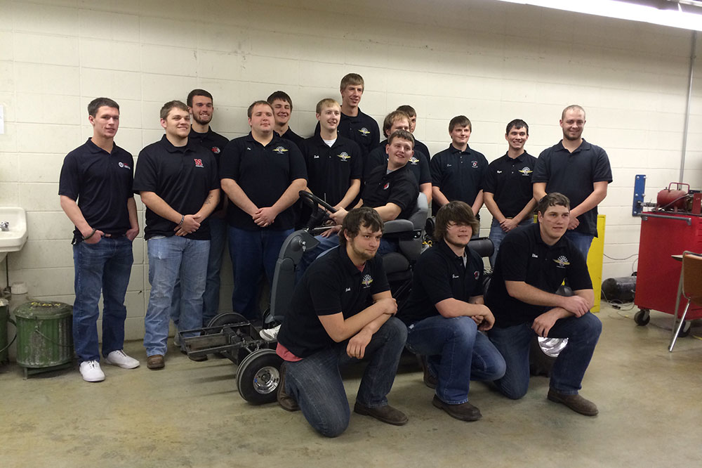 With his family and caregivers along, Caleb navigated in a wheelchair to the Quarter Scale Team’s workspace in the Splinter Labs, part of UNL’s Tractor Test Lab facilities at East Campus. The team gathered to show Caleb their progress during the winter months, and soon the students brought the 2014 tractor to the test track outside. With excitement and enthusiasm they lifted Caleb into the driver’s seat, and team members flanked both sides of the tractor as Caleb took the creation for a short drive.