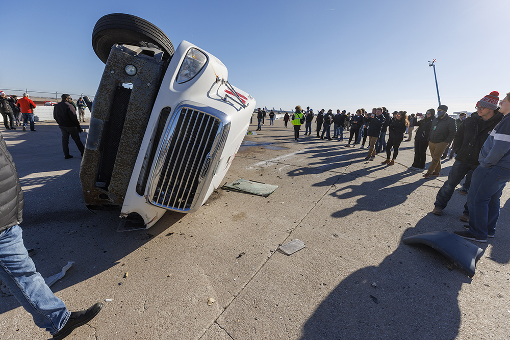 Those who witnessed the test at the Outdoor Proving Grounds inspect the truck after the crash. (Craig Chandler / University Communication)