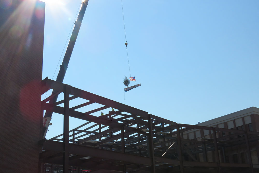 The final steel beam is raised during the Topping Out ceremony for Phase 1 of the college's construction project.