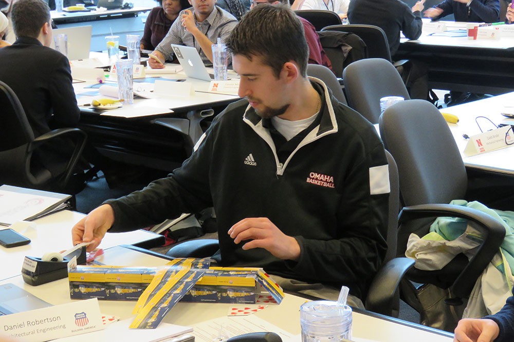 Daniel Robertson, an architectural engineering major, builds an airplane using a deck of playing cards and clear tape during the Thinking Big: Team Competition Wednesday (March 22) at the Complete Engineer Conference.