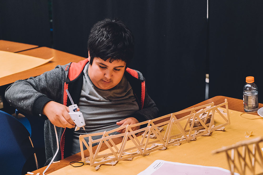 A student works to construct a bridge during the 