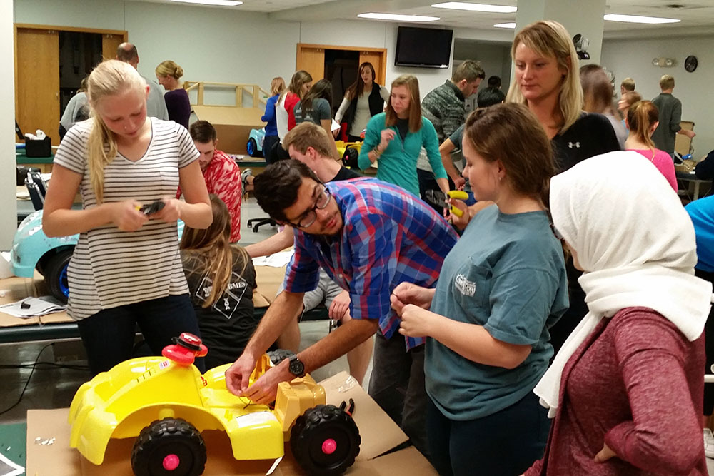 A team of biological systems engineering students works on a car as part of their senior design capstone project. This team is addressing issues to make future Go Baby Go cars easier for the children to operate.