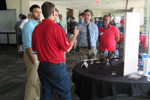 Visitors listen to an explanation of a drone surveillance system developed by electrical and computer engineering students Brandon Guenther, Jack Olson, Joe Gonzalez and Kossivi Agbenohevi.