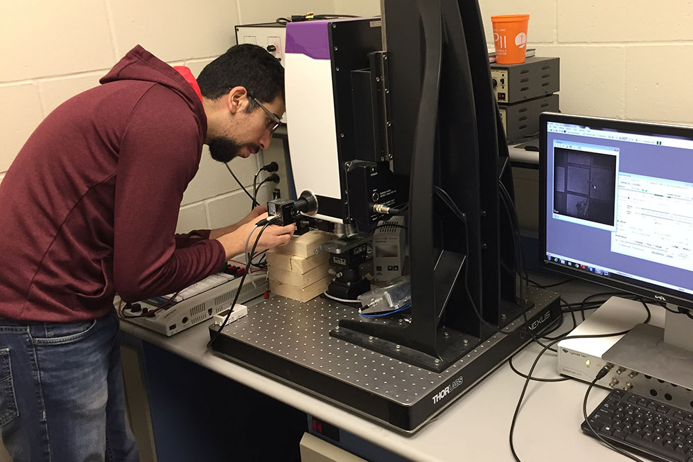 Mohamad H Hasan, a Ph.D. student in mechanical and materials engineering, works on a sample of soft material that has MEMS technology.