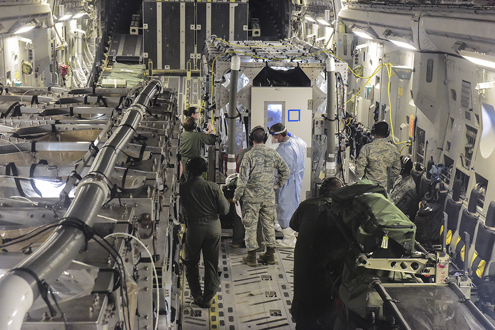 Air Force personnel work outside the transport isolation system (TIS) during a 2018 mission simulating the retrieval and care for patients exposed to an infectious disease.