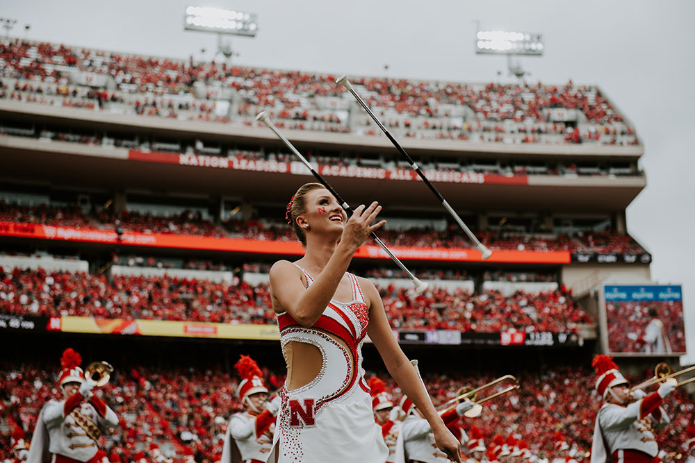 An accomplished second-generation twirler, Kimberly Law uses two batons during a Sept. 8 performance of the Cornhusker Marching Band. (Photo by Justin Mohling)