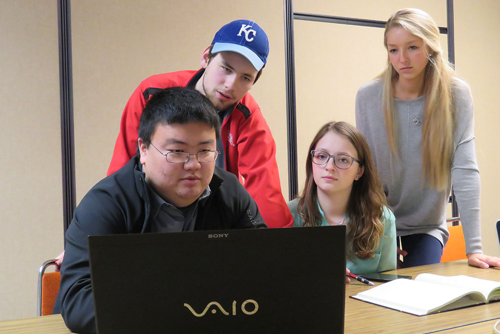 A team of biological systems engineering students -- (from left) Yuki Naoe, Doug Rowen, Merrill Brady and Kristina Zvolanek -- go over their design of the Pivot Panel, which would help VA hospital radiology technicians more safely assist patients off an X-ray table.