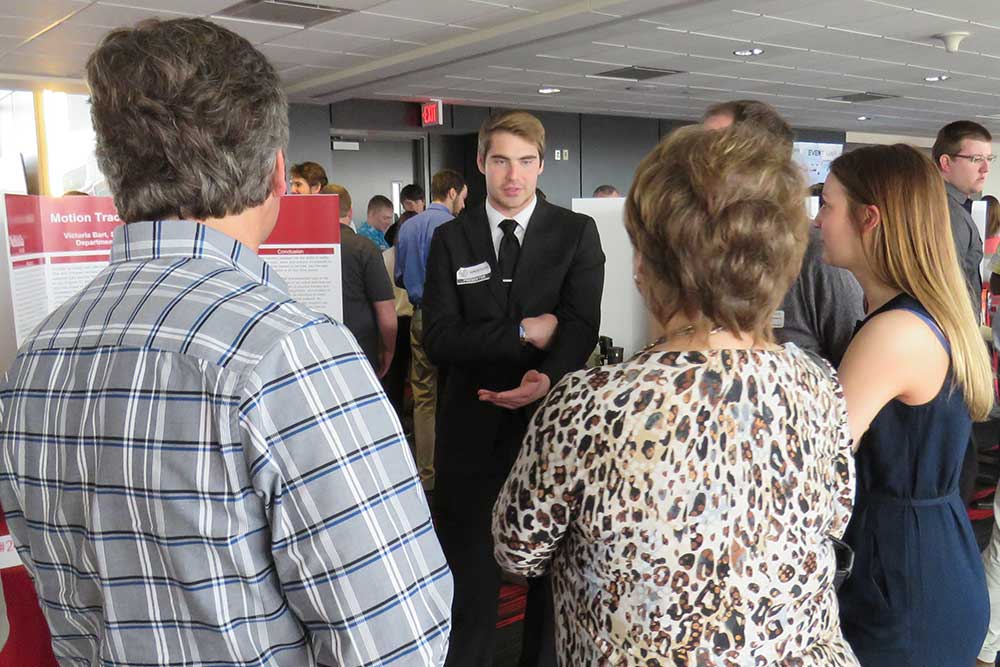 Biological Systems Engineering student Kevin Real discusses his team's project --Motion Tracking of Neonate Activity -- with guests at the Senior Design Showcase on April 21. 