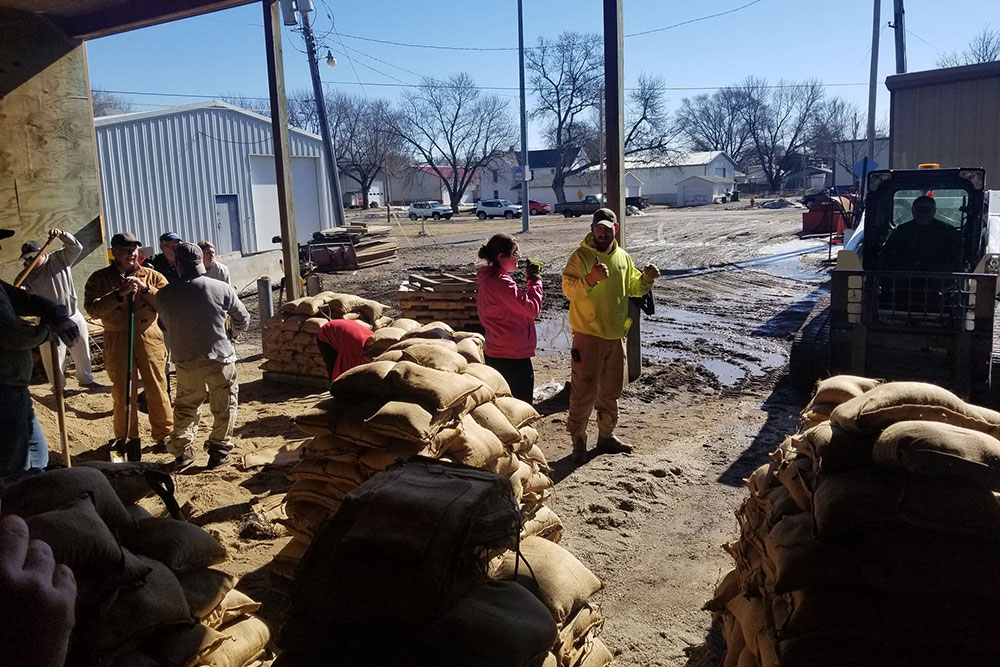 Volunteers take a break from making sandbags that would be used to bolster the levee along the Elkhorn River on the east edge of Waterloo.