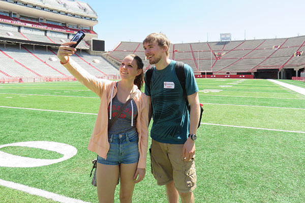 Two guests taking an engineering tour of Memorial Stadium stop to take a selfie on April 22 at the Senior Design Showcase.